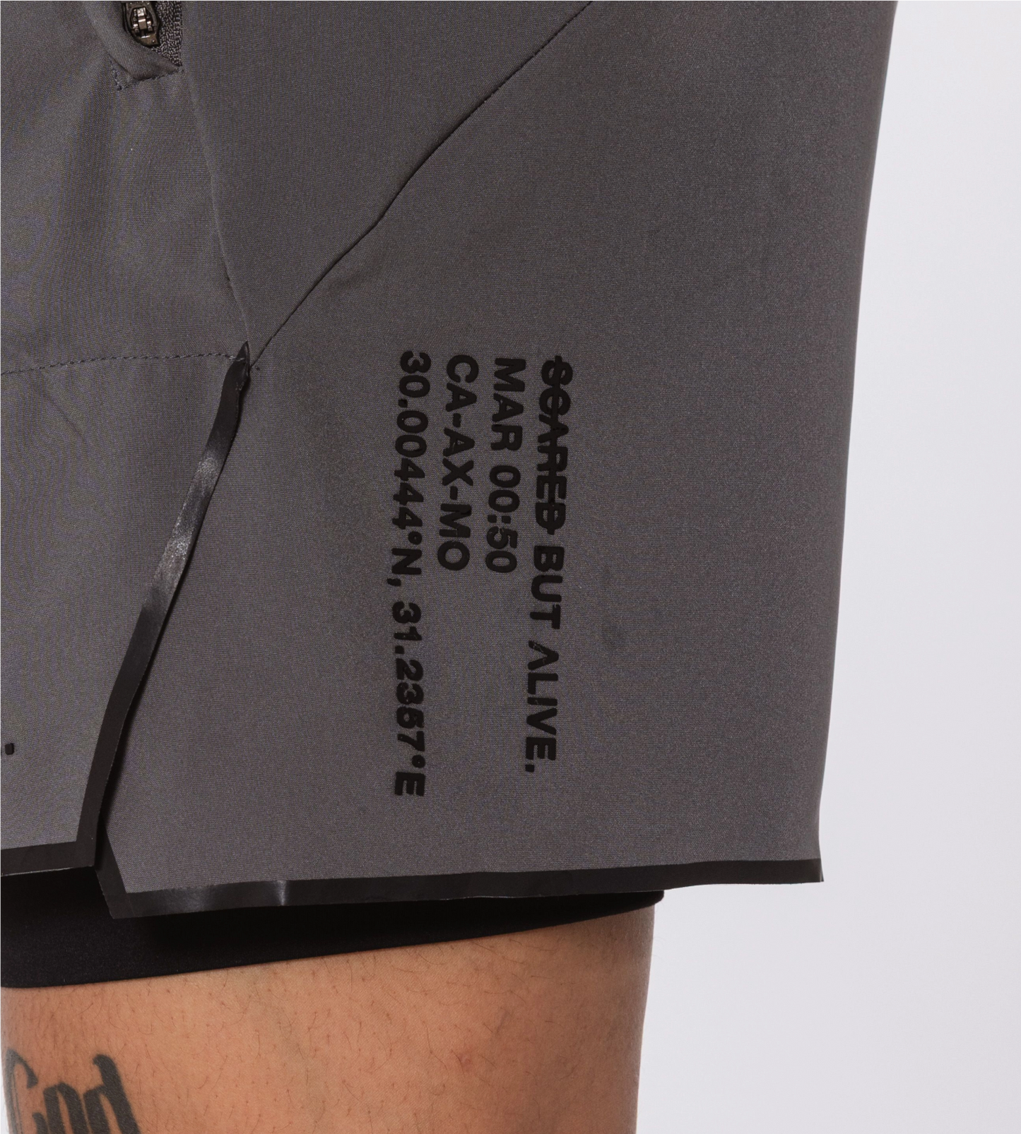 [Color: Carbon Gray] Model wearing the Berlin Shorts, zoomed in on the Scared But Alive logo print