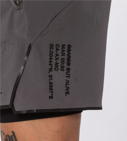 [Color: Carbon Gray] Model wearing the Berlin Shorts, zoomed in on the Scared But Alive logo print