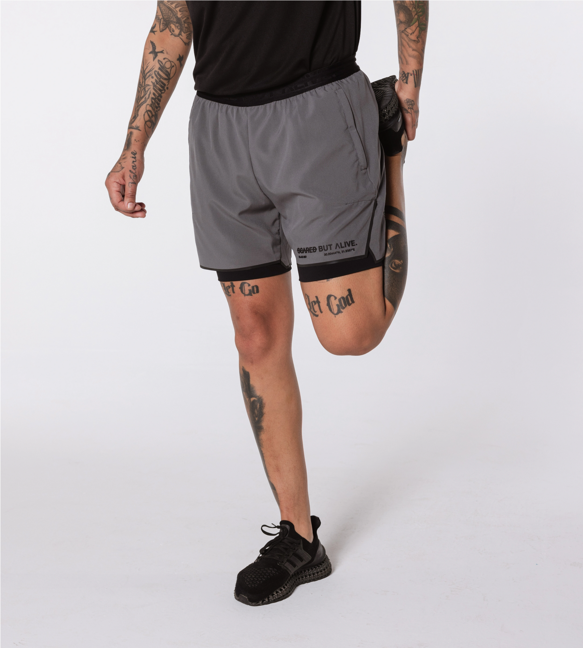 [Color: Carbon Gray] Model wearing the Berlin Shorts while stretching
