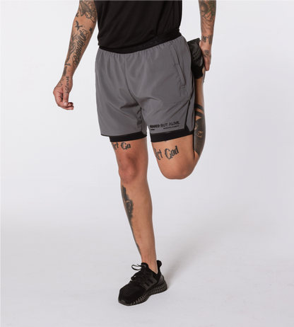 [Color: Carbon Gray] Model wearing the Berlin Shorts while stretching